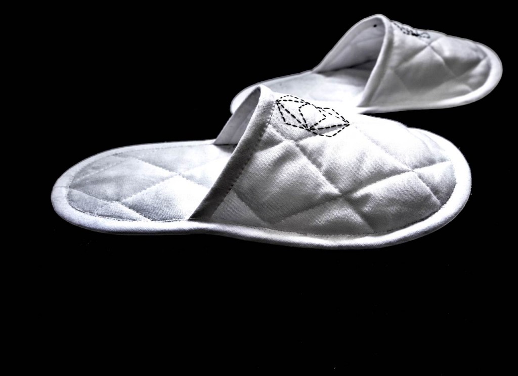 Paire de chaussons blancs en cotton brodés sur fond noir