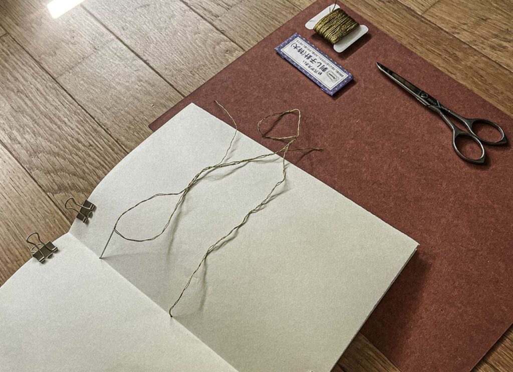 Thread and needle binding pages into a companion
