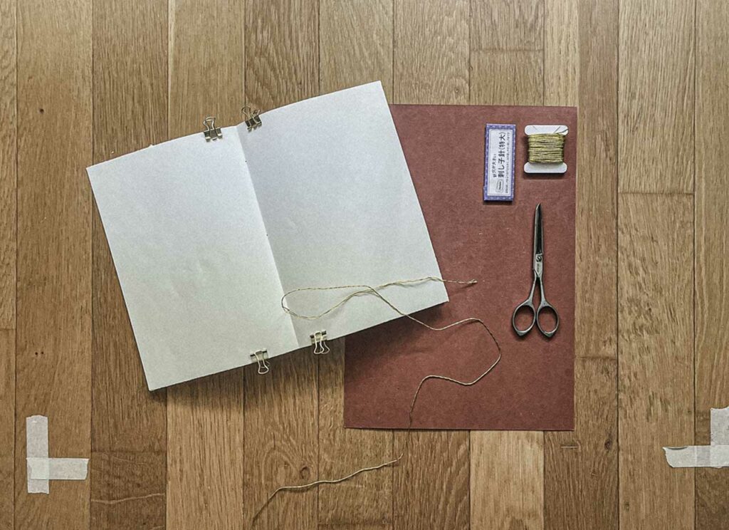 Thread and needle binding pages into a companion